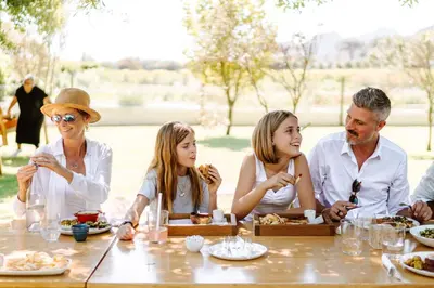 a family sitting around a table eating food at Last Word Franschhoek in Franschhoek