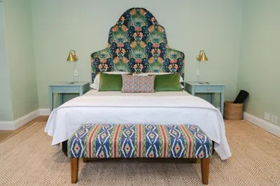 a bedroom with a large bed with a headboard and two tables at Last Word Franschhoek in Franschhoek
