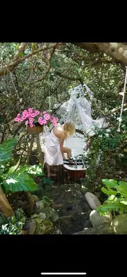 a woman in a white dress sitting at a table at Kennedys Beach Villa in Hermanus
