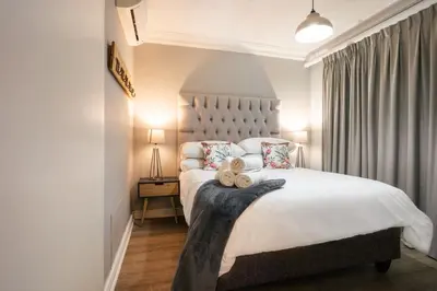 a bedroom with a large bed with two teddy bears on it at Avemore Jan Cats No 2 full power back up in Stellenbosch