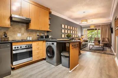 a kitchen with a washer and dryer in it at Avemore Jan Cats No 2 full power back up in Stellenbosch