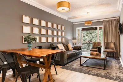 a living room with a table and a couch at Avemore Jan Cats No 2 full power back up in Stellenbosch