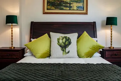 a bedroom with a bed with yellow pillows at Carmichael House Boutique Hotel in Cape Town