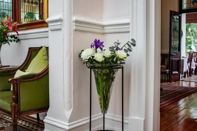 a vase of flowers on a stand in a room at Carmichael House Boutique Hotel in Cape Town