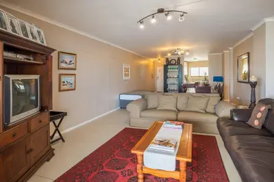 a living room with a couch and a tv at Luxurious Beach Front in Strand