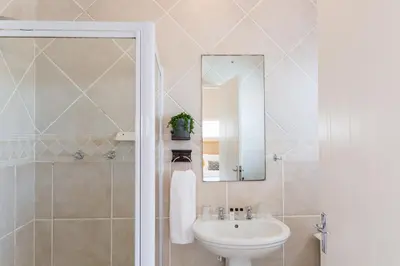 a bathroom with a sink and a mirror at Atlantic Beach Villa in Cape Town