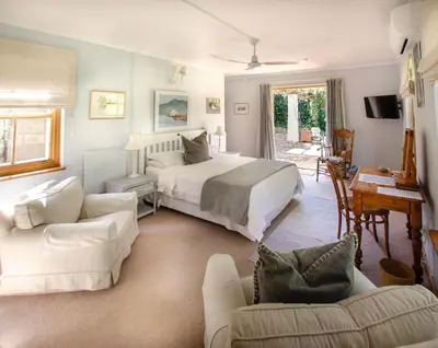 a bedroom with a bed and a living room at Languedoc in Stellenbosch