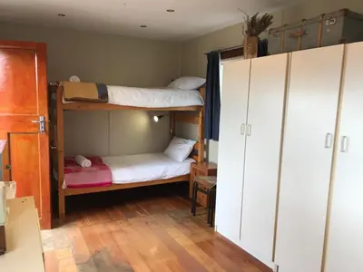 a room with two bunk beds and a closet at The Yard in Gordonʼs Bay