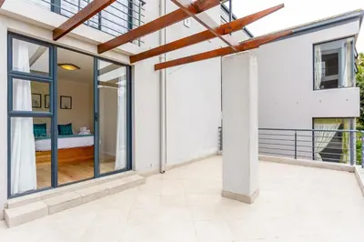 a room with sliding glass doors and a balcony at Waterstone A103 by CTHA in Cape Town