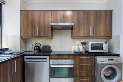 a kitchen with a microwave oven and a dishwasher at Waterstone A103 by CTHA in Cape Town
