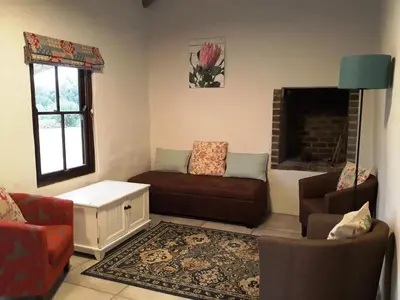 a living room with a couch and a fireplace at The Cottage at Nuwejaarsrivier Farm in Kleinmond