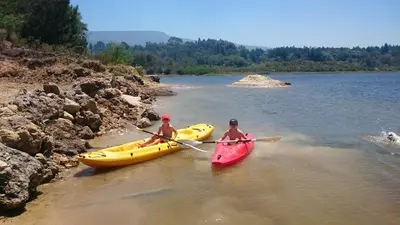 two people in kayaks in the water on a river at The Cottage at Nuwejaarsrivier Farm in Kleinmond