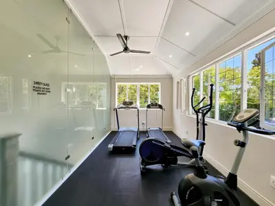 a gym with a treadmill and a bike in a room at Roodenburg House in Cape Town