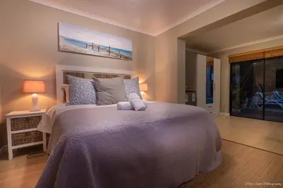 a bedroom with a bed with a painting on the wall at Atlantic Bay Lodge in Cape Town