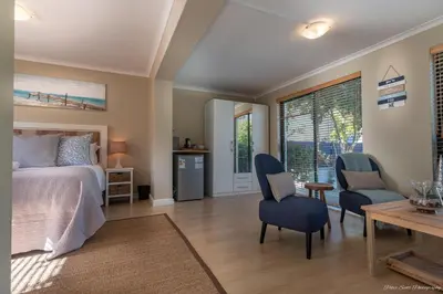 a bedroom with a bed and a table and chairs at Atlantic Bay Lodge in Cape Town