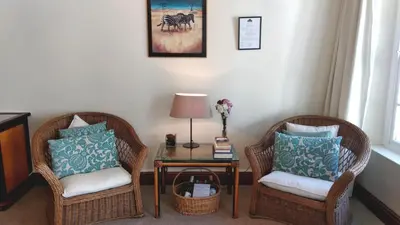 a room with two chairs and a table with a lamp at Le Manoir de Brendel in Franschhoek