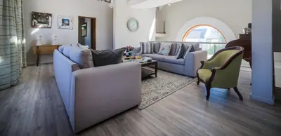 a living room with two couches and a table at Zorgvliet Wines Country Lodge in Stellenbosch