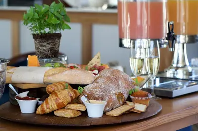 a table topped with a plate of bread and pastries at Zorgvliet Wines Country Lodge in Stellenbosch