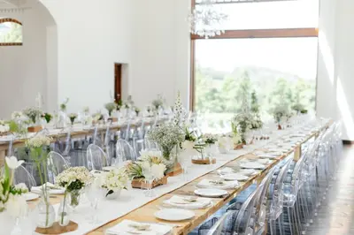 a long table with white plates and plants on it at Zorgvliet Wines Country Lodge in Stellenbosch