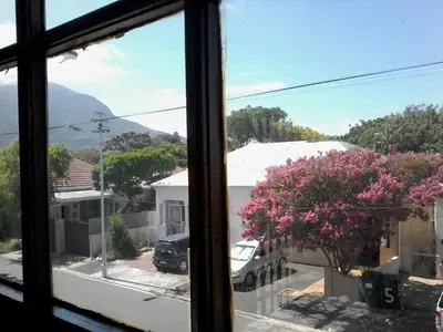a window view of a street with a tree with pink flowers at Nansen Place in Cape Town