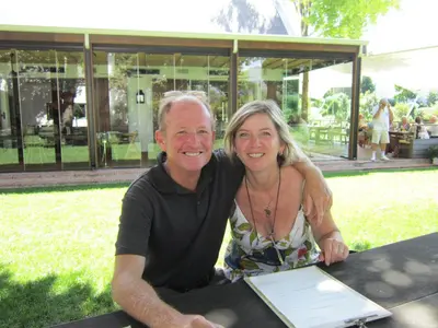 a man and woman sitting at a table with a laptop at La Roche Guest House in Cape Town