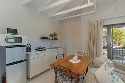 a kitchen and a living room with a table and a kitchen at Cape Goodness in Bellville
