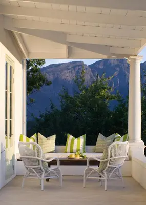 a porch with chairs and a table with a view at La Cotte Orchard Cottages in Franschhoek