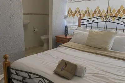 a bedroom with a bed with a towel on it at Cape Pine Guest House in Kuilsrivier