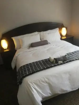 a bed with a teddy bear sitting on top of it at Cape Pine Guest House in Kuilsrivier