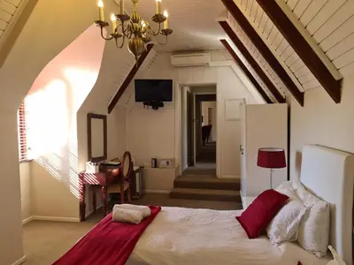a bedroom with a bed and a chandelier at Dark Chocolate Guest House in Durbanville