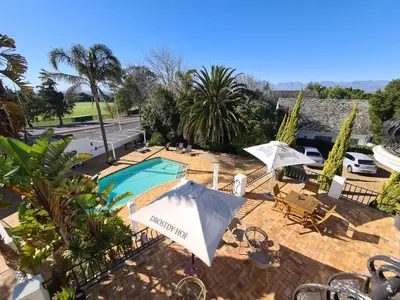 a swimming pool with umbrellas and chairs and a pool at Dark Chocolate Guest House in Durbanville