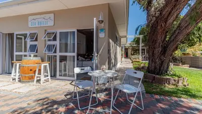 a table and chairs in front of a building at Sea Breeze Guest House in Bloubergstrand