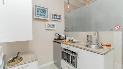 a kitchen with a sink and a counter top at Sea Breeze Guest House in Bloubergstrand