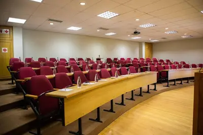 a conference room with red chairs and a long table at Zevenwacht Country Inn in Kuilsrivier