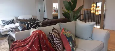 a living room with a couch with pillows on it at The Whale's Tale Guesthouse in Hermanus