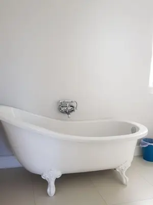 a white bath tub sitting in a bathroom at Coral Tree in Hermanus