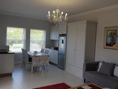 a kitchen and dining room with a table and a couch at Coral Tree in Hermanus