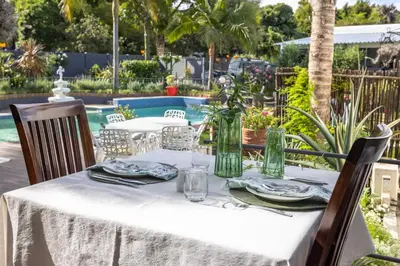 a table with a white tablecloth and plates and glasses at Cape Pillars Boutique Hotel in Durbanville