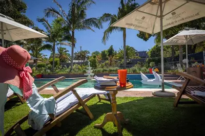 a backyard with a table and chairs and a pool at Cape Pillars Boutique Hotel in Durbanville