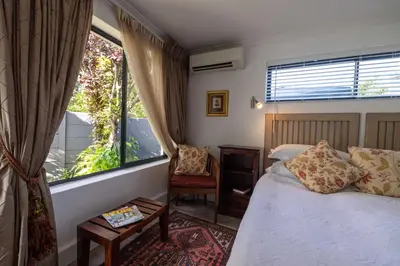 a bedroom with a bed and a window at Cape Pillars Boutique Hotel in Durbanville