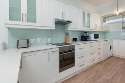 a kitchen with white cabinets and a stove top oven at Bayview Bliss in Hermanus