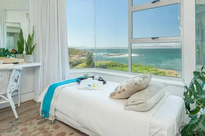 a bedroom with a bed and a large window at Bayview Bliss in Hermanus