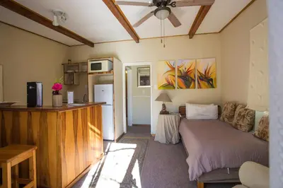 a room with a bed and a kitchen with a refrigerator at Damas Guest Farm in Worcester