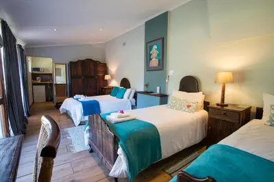 a hotel room with three beds with blue and white at Damas Guest Farm in Worcester
