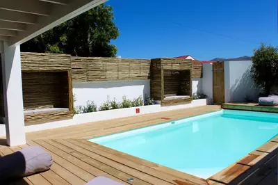 a swimming pool on a wooden deck with at Whale Rock Luxury Lodge in Hermanus