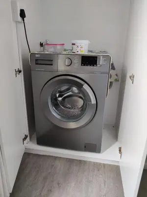 a washing machine in a corner of a room at House 10-on-Sea in Hermanus