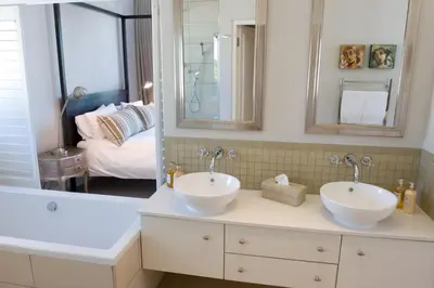 a bathroom with two sinks and a tub and a mirror at 14 On Louw in Stellenbosch