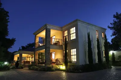 a large house at night with its lights on at Blaauwheim Guest House in Somerset West