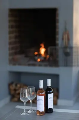 two bottles of wine and two wine glasses on a table at Sweetwater Guesthouse in Wellington