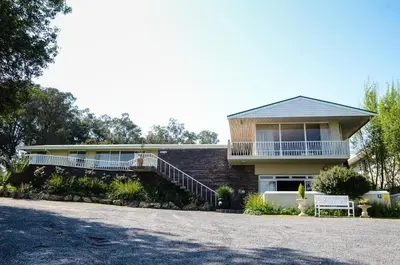 a brick house with a porch and a balcony at Groenvlei Guest Farm in Kuilsrivier